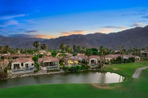an aerial view of residential houses with outdoor space and lake view