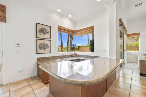 a bathroom with a granite countertop sink a toilet and a mirror