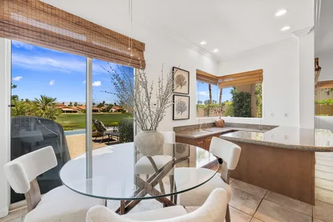 a large kitchen with kitchen island a sink a stove a dining table and chairs