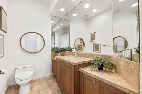 a bathroom with a granite countertop sink a toilet and shower