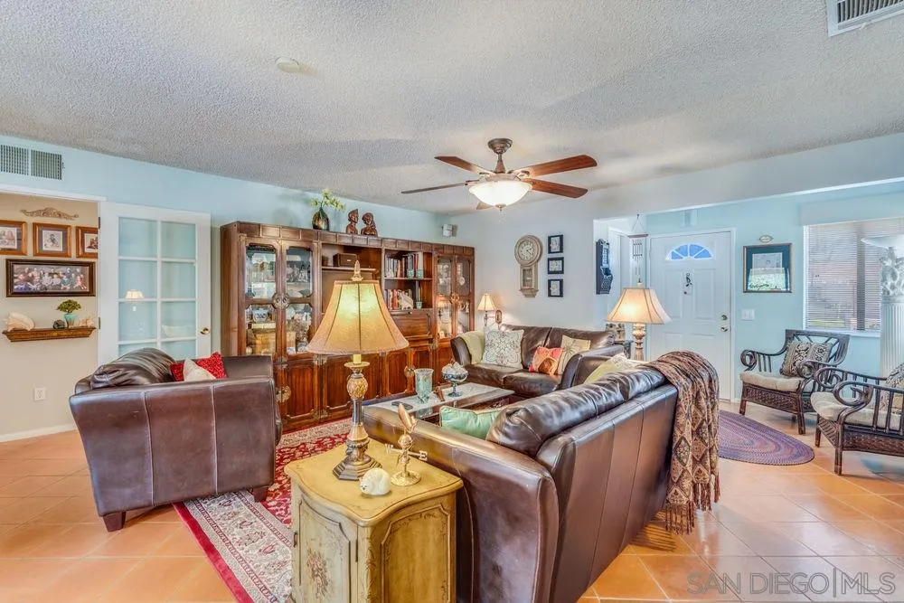 9468 Domer Road Santee, CA 92071 - Photo 3 of 25 a living room with furniture a chandelier and a flat screen tv