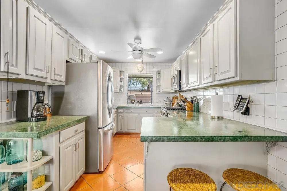 9468 Domer Road Santee, CA 92071 - Photo 8 of 25 a kitchen with stainless steel appliances granite countertop a refrigerator a stove a sink dishwasher and white cabinets with wooden floor