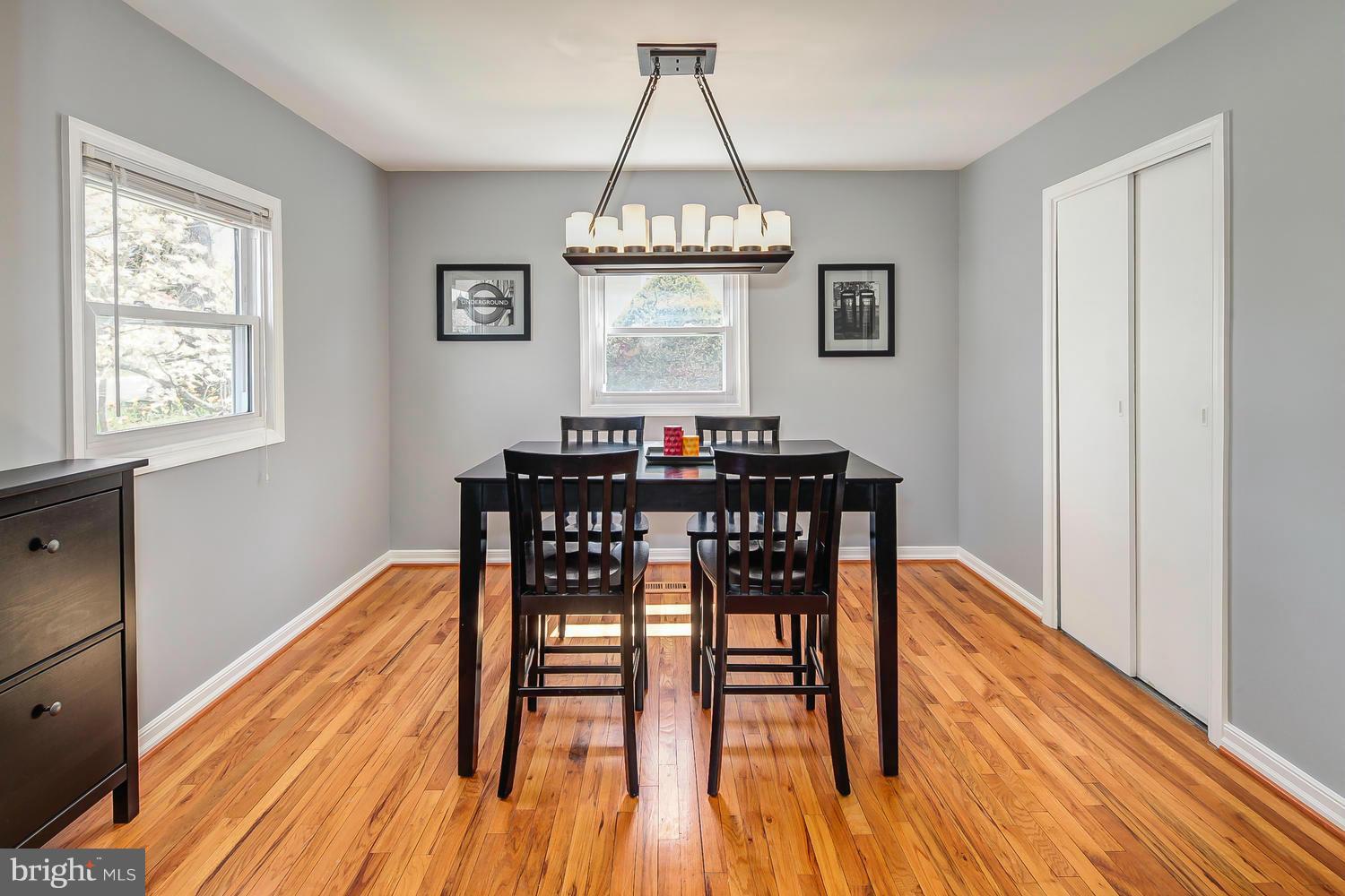 12304 Middle Road Silver Spring, MD 20906 - Photo 5 of 30 a dining room with wooden floor a chandelier a wooden table and chairs