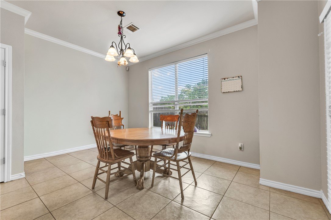1425 West Villa Maria Road, Unit 1004 Bryan, TX 77801 - Photo 7 of 23 a dining room with chandelier and wooden floor