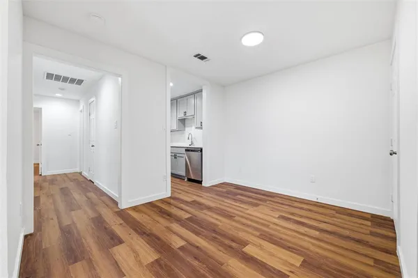 a kitchen with a sink dishwasher a stove and a refrigerator with wooden floor