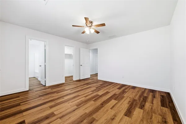 a view of an empty room with window and wooden floor
