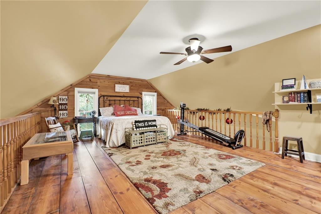 1050 Robinson Road Dahlonega, GA 30533 - Photo 18 of 28 a spacious bedroom with a bed a couch and a chandelier