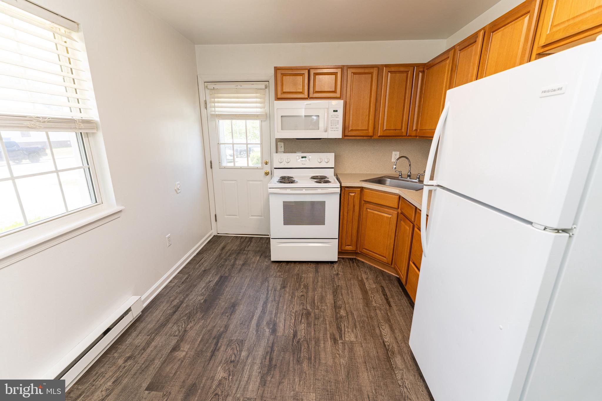30704 Hampden Avenue Princess Anne, MD 21853 - Photo 11 of 31 a kitchen with a refrigerator a stove and wooden floor