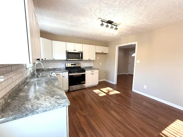 a kitchen with kitchen island a stove a sink and a microwave