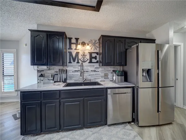 a kitchen with stainless steel appliances granite countertop a sink a stove and cabinets