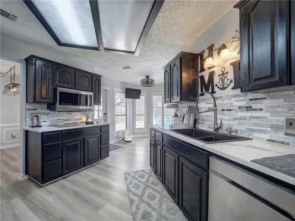 a kitchen with stainless steel appliances granite countertop a sink stove microwave and cabinets