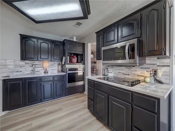 a kitchen with stainless steel appliances kitchen island granite countertop a sink stove and refrigerator