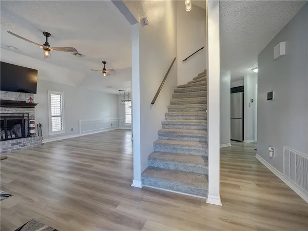 a view of empty room with wooden floor and ceiling fan