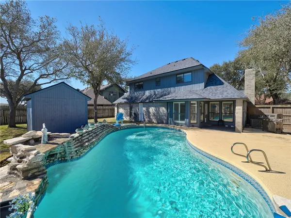 a view of a backyard with a tub and wooden fence
