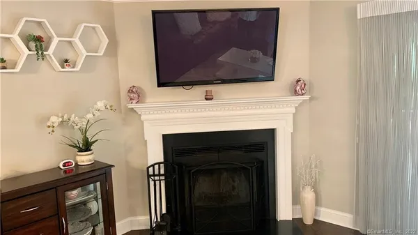 a living room with a fireplace and wooden floor