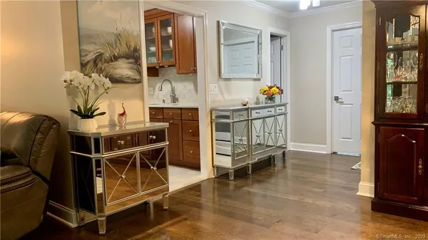 a living room with a floor to ceiling window and wooden floor