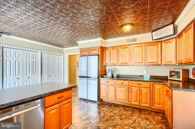 a kitchen with stainless steel appliances granite countertop a stove a sink and a refrigerator