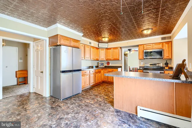 a kitchen with stainless steel appliances a refrigerator and a stove top oven