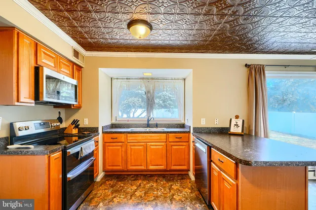 a kitchen with granite countertop sink stove and cabinets