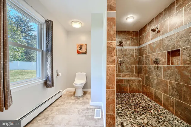 a bathroom with a toilet and a shower