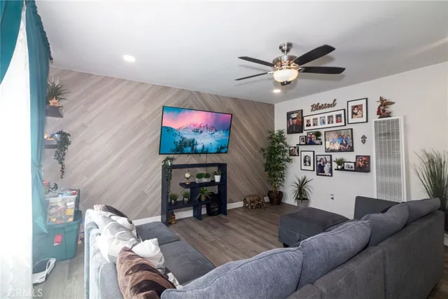 a living room with furniture and a flat screen tv with kitchen view