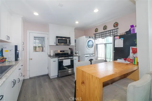 a kitchen with granite countertop a sink appliances cabinets and counter space