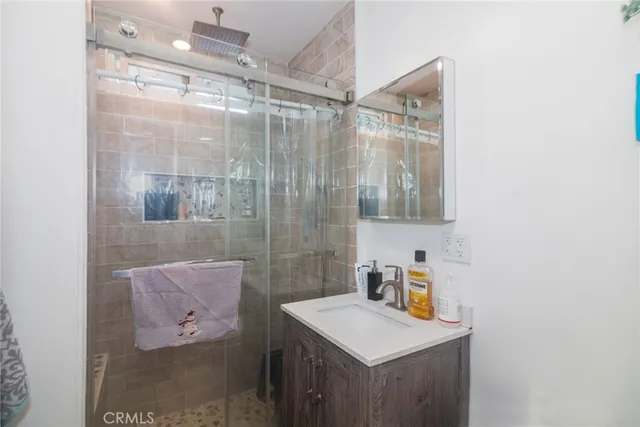 a bathroom with a shower sink and mirror