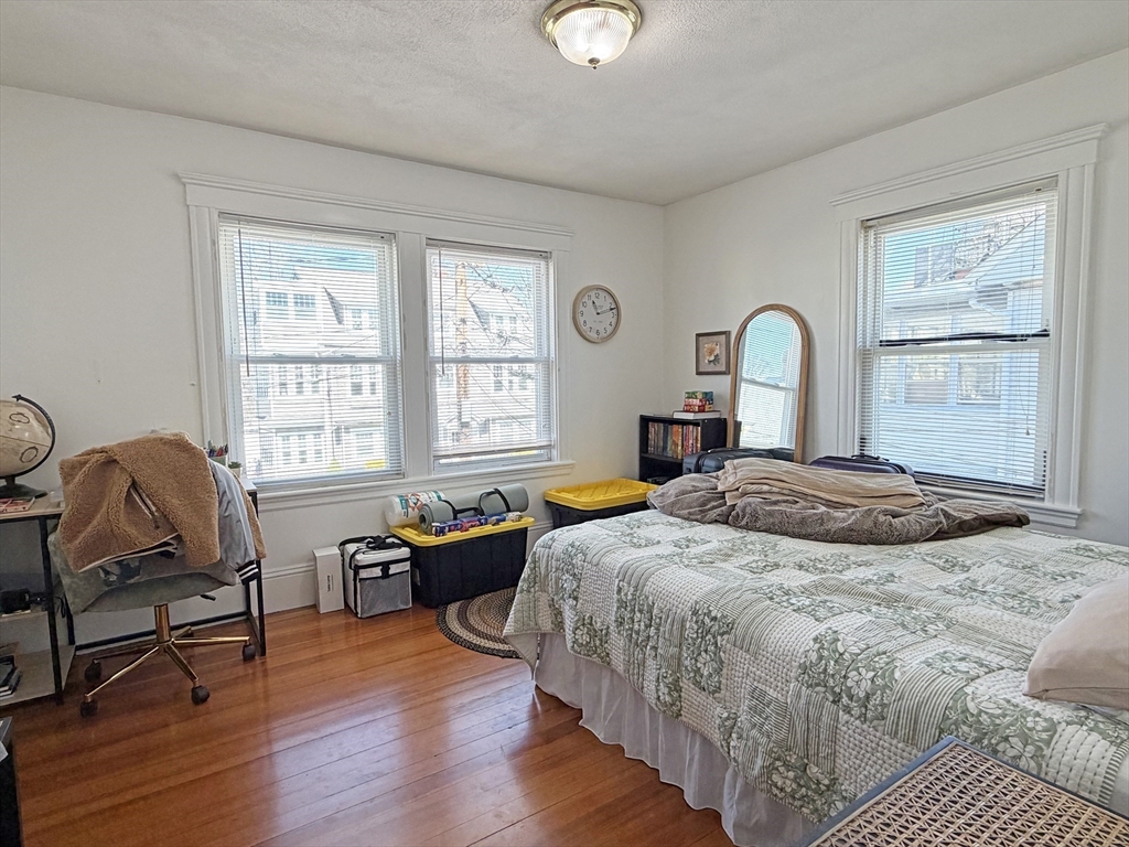 12-14 Nottingham Street Newton, MA 02459 - Photo 20 of 29 a bedroom with a bed a table chair and a window
