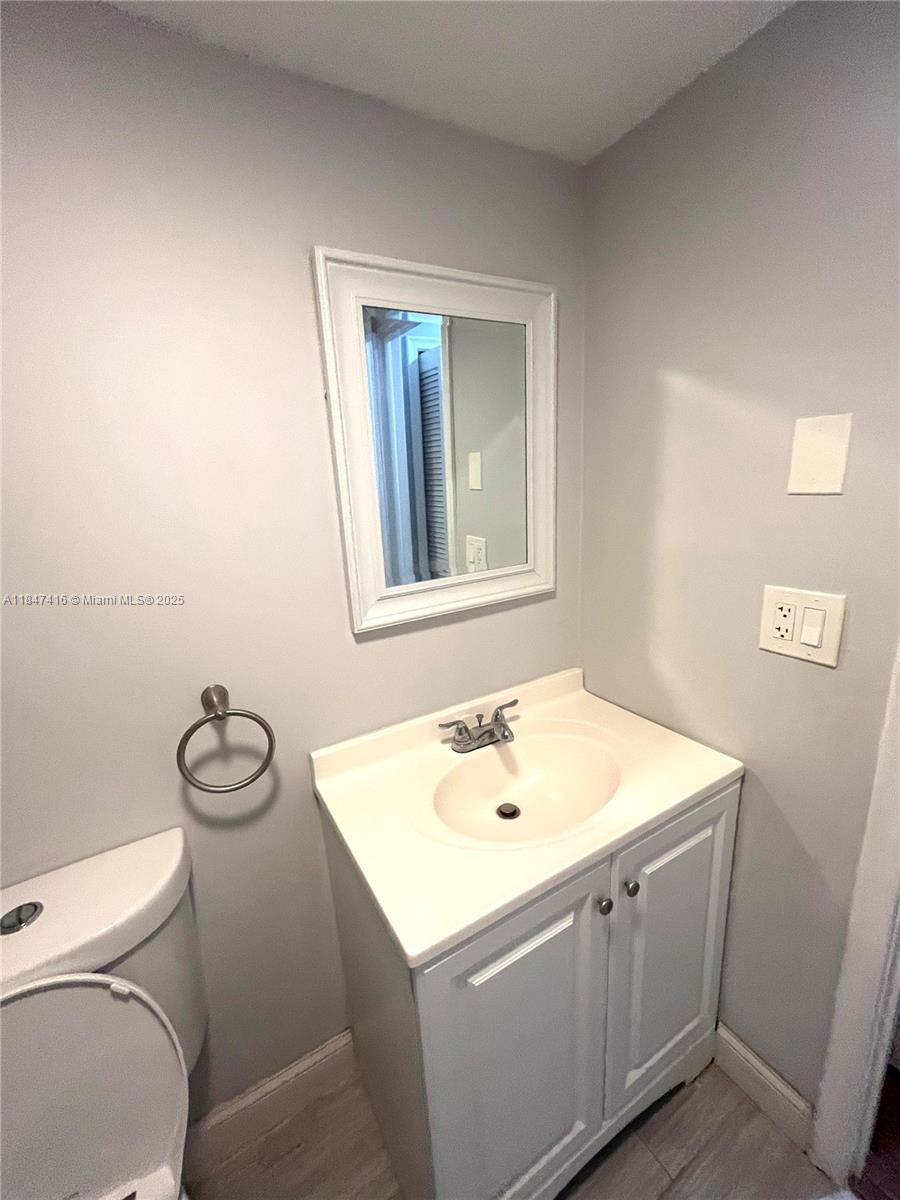 8404 West Sample Road, Unit 131 Coral Springs, FL 33065 - Photo 12 of 36 a bathroom with a sink toilet and mirror