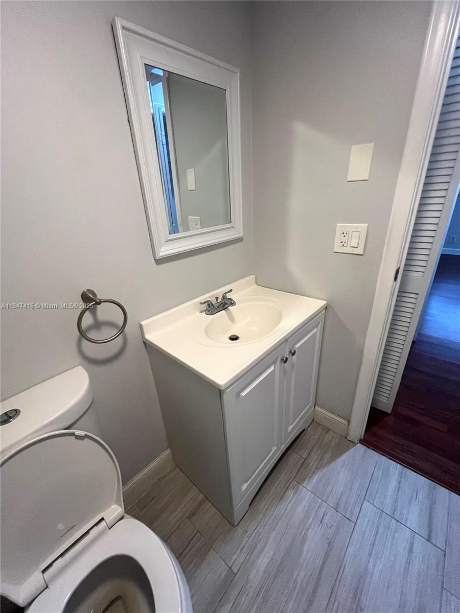 8404 West Sample Road, Unit 131 Coral Springs, FL 33065 - Photo 14 of 36 a bathroom with a toilet sink and mirror