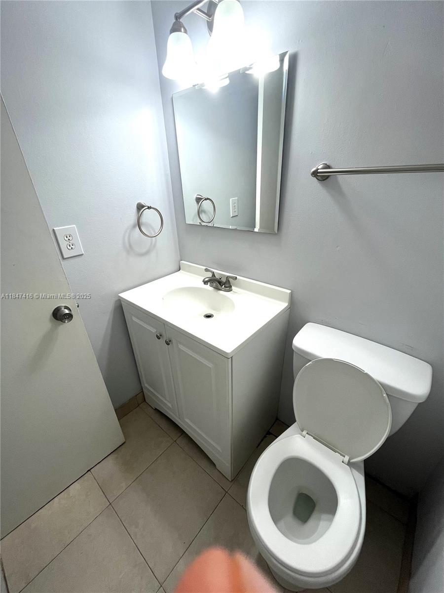 8404 West Sample Road, Unit 131 Coral Springs, FL 33065 - Photo 17 of 36 a bathroom with a toilet sink and mirror