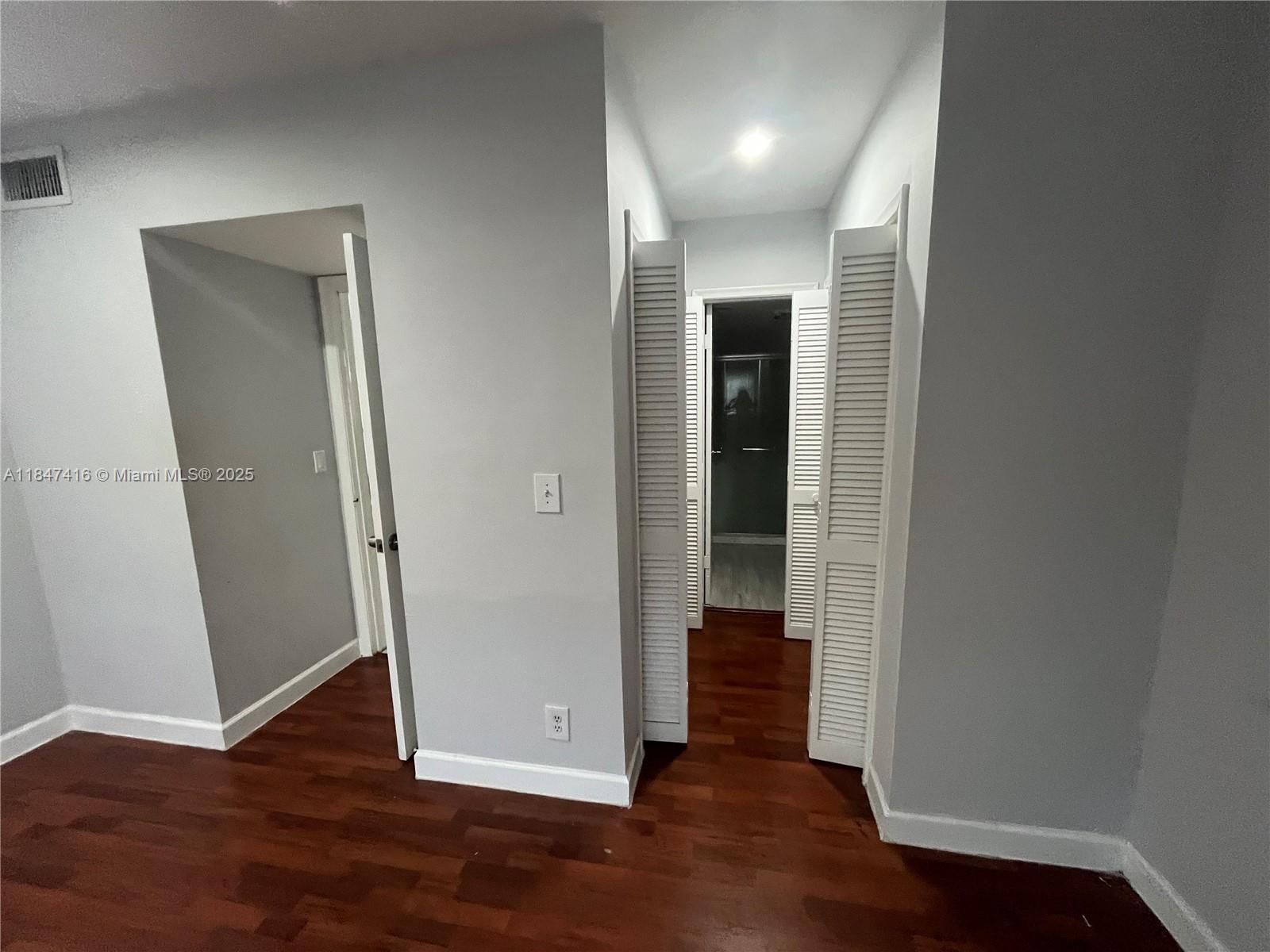 8404 West Sample Road, Unit 131 Coral Springs, FL 33065 - Photo 24 of 36 an empty room with wooden floor and closet