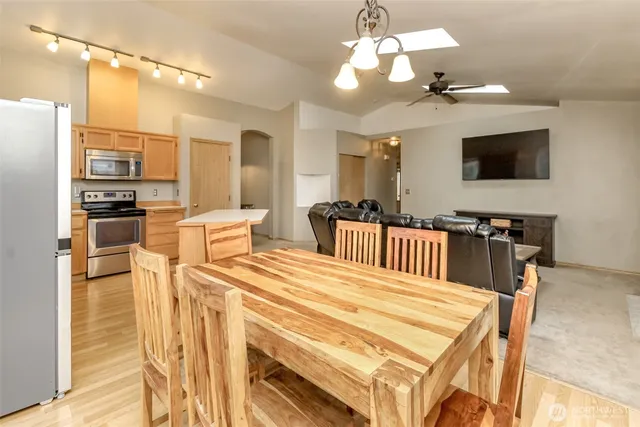 a kitchen with stainless steel appliances kitchen island granite countertop a refrigerator and a stove top oven