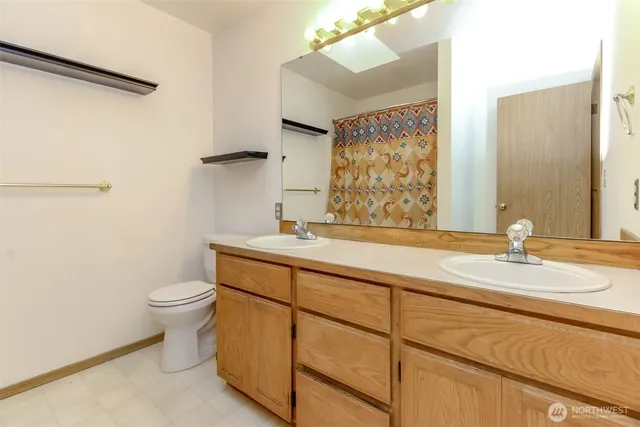 a bathroom with a granite countertop sink mirror vanity and toilet