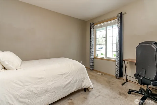 a bedroom with a bed a table and a window