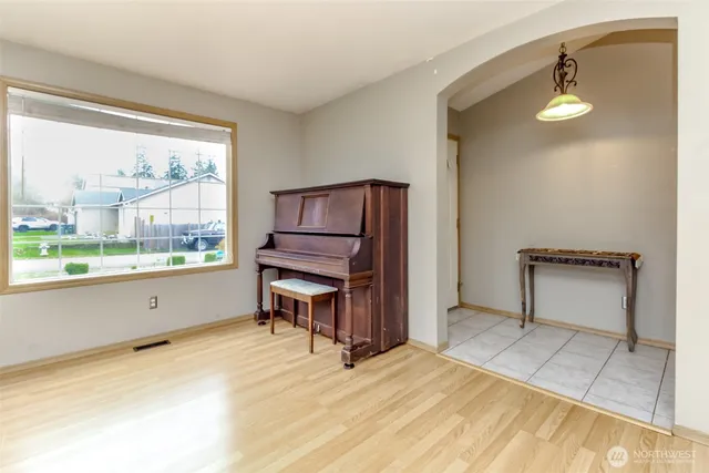 a room with a bed and a potted plant next to a window