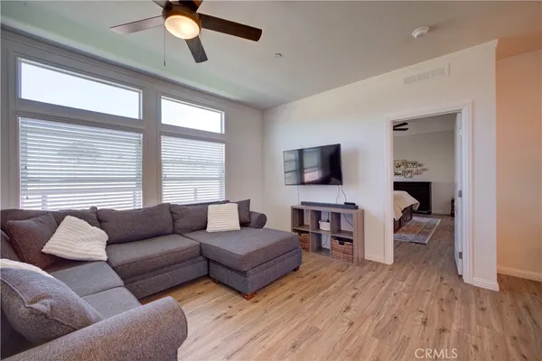 a living room with furniture flat screen tv and wooden floor