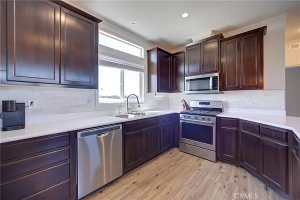 a kitchen with wooden cabinets and stainless steel appliances