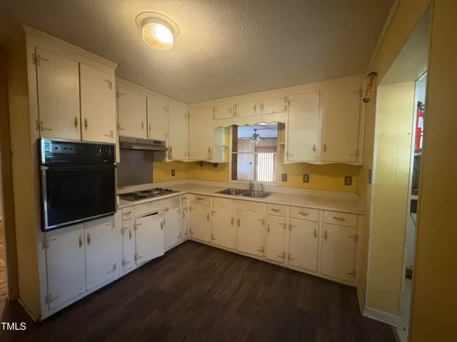a kitchen with sink a microwave and cabinets