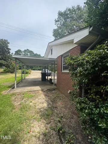 a view of a porch with furniture and a yard