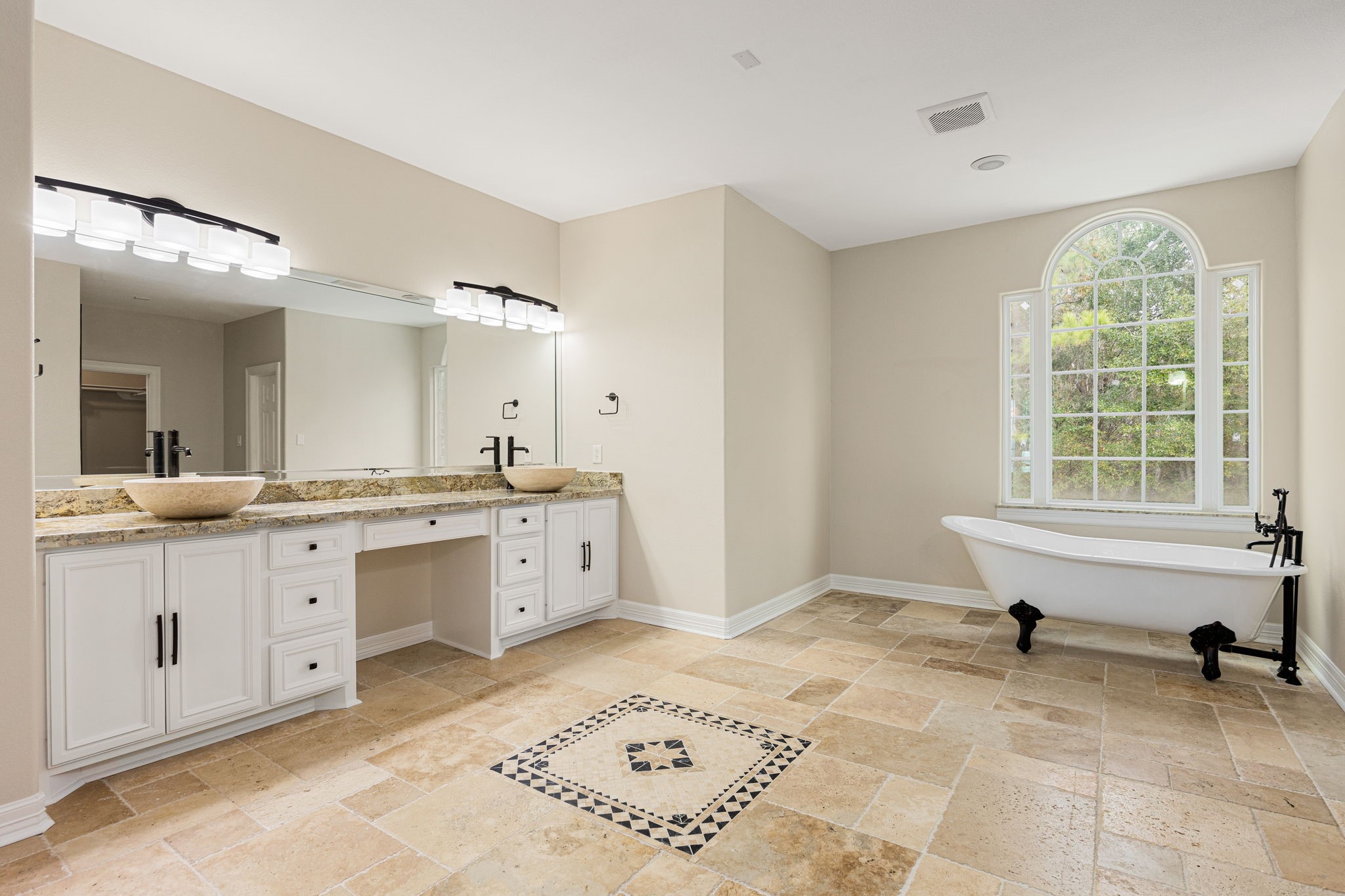 14882 Gingham Road Montgomery, TX 77356 - Photo 31 of 41 Spacious ensuite primary bathroom featuring a double vanity with dual sinks, a classic freestanding bathtub, and large window providing ample natural light.