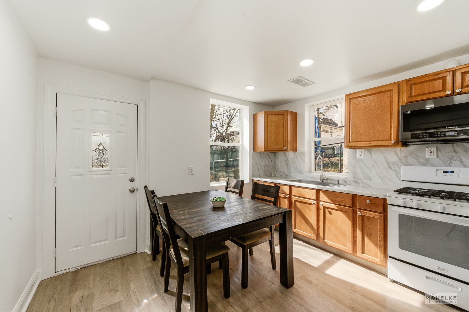 363 Franklin Boulevard Elgin, IL 60120 - Photo 14 of 32 a kitchen with granite countertop a stove top oven a sink dishwasher and white cabinets with wooden floor