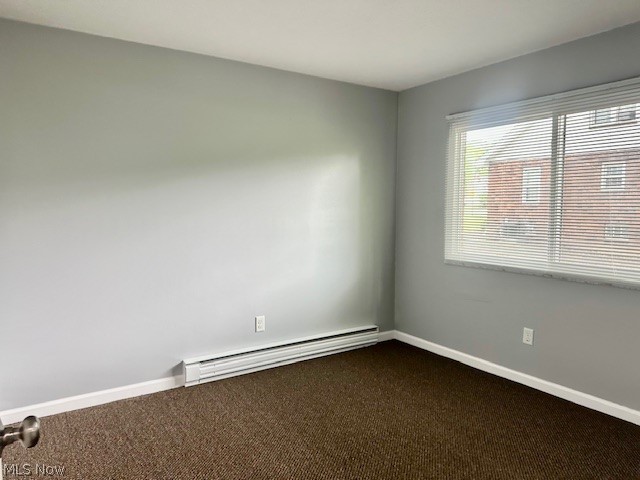 4376 Darrow Road, Unit 2 Stow, OH 44224 - Photo 19 of 26 Empty room featuring a baseboard heating unit, dark colored carpet, and baseboards