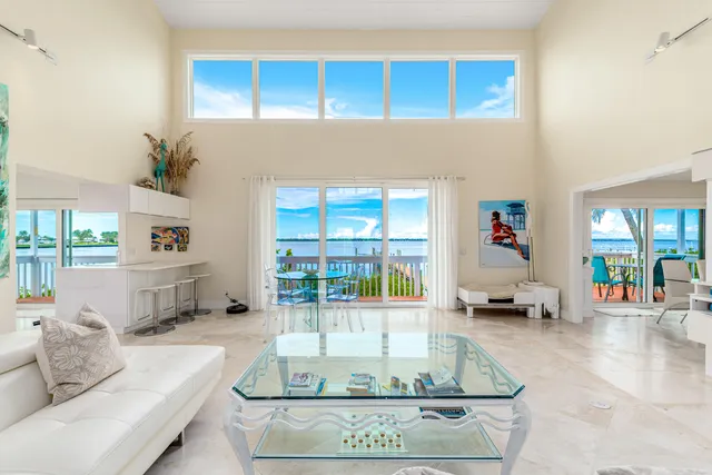 a living room with furniture a flat screen tv and a large window