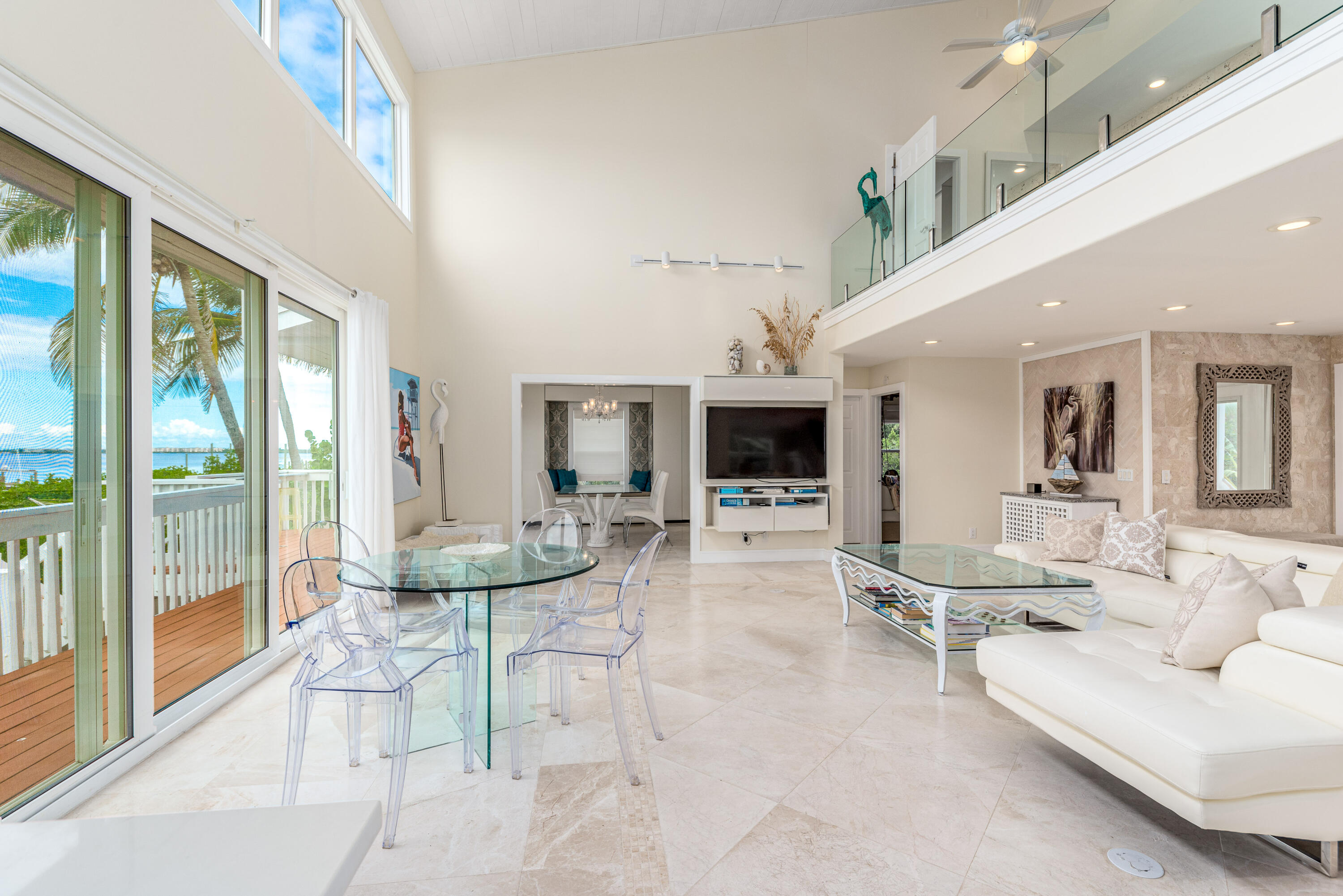 1470 Southeast MacArthur Boulevard Stuart, FL 34996 - Photo 3 of 15 a living room with furniture a flat screen tv and a large window