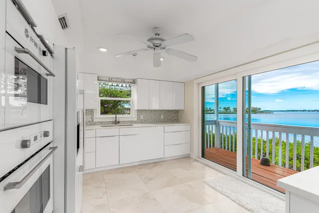 a kitchen with stainless steel appliances kitchen island granite countertop white cabinets and refrigerator