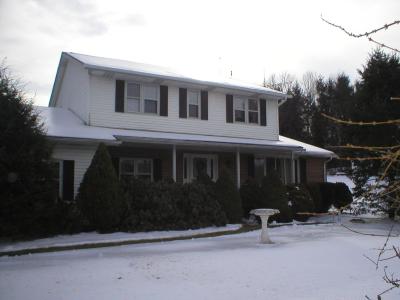 a front view of a house with yard and parking