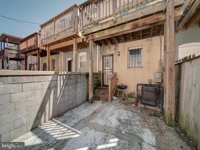 a view of a house with a barbeque and wooden stairs