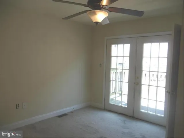 an empty room with a window and a fan