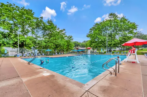 a view of a swimming pool with a table and chairs under an umbrella